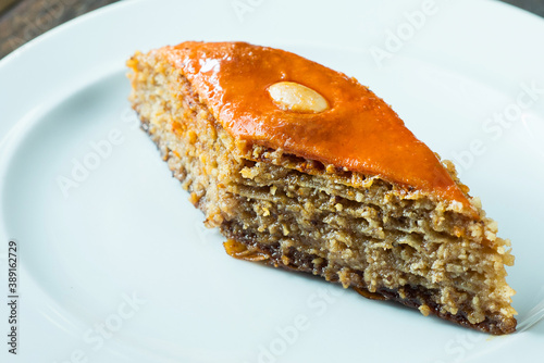 Traditional arabic dessert baklava with cashews, walnuts and cardamom with eucalyptus branch on a wooden table.....