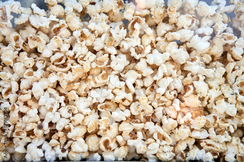 Popcorn background behind glass in a po pcorn maker.