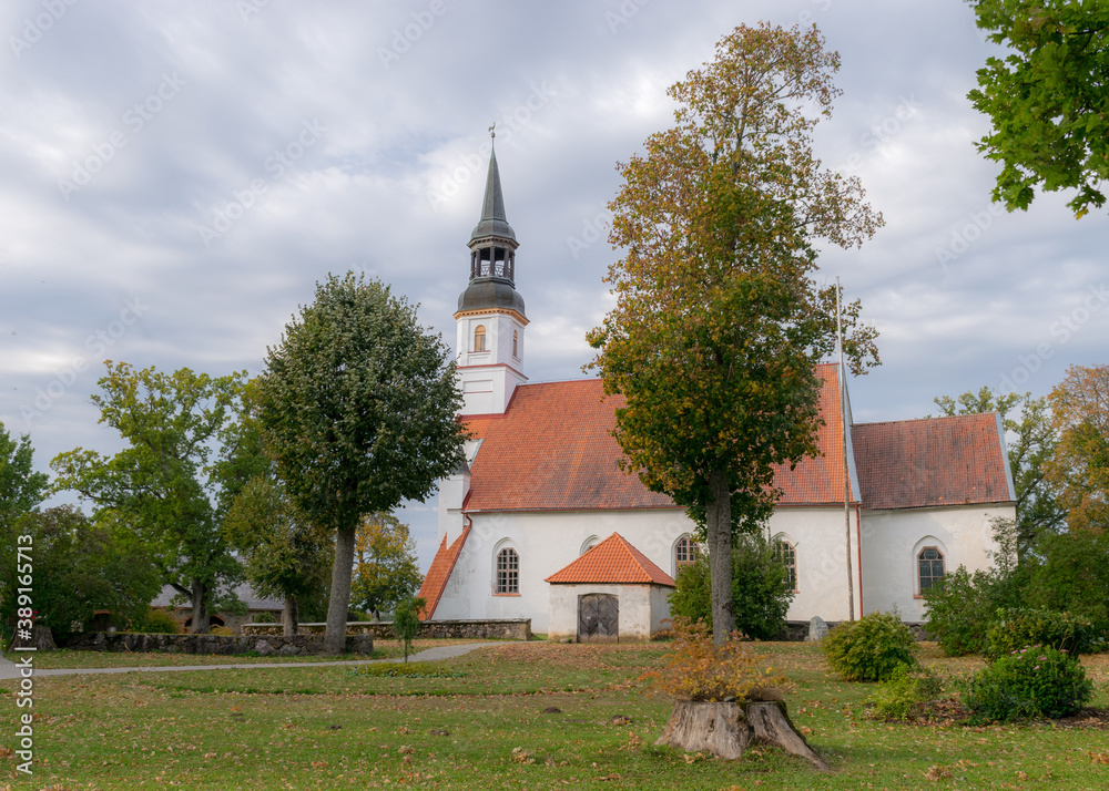 white church with a red roof, church bell tower, surrounded by trees in autumn colors