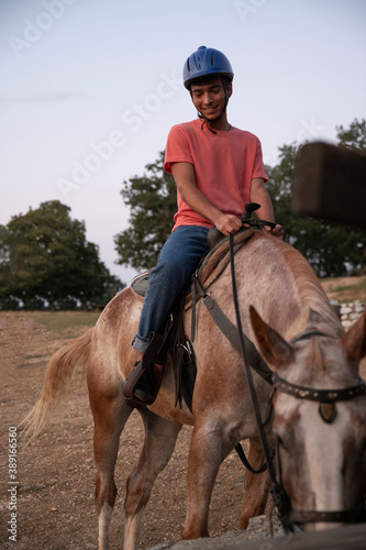 A Man Sitting on a Horse when the Horse Eating. Ranch Concept Photography © Nick Paschalis