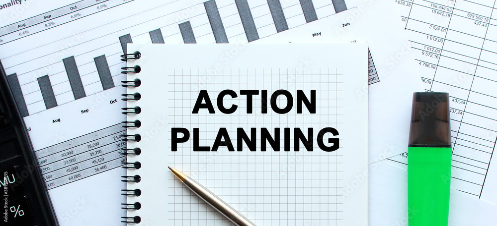 Text ACTION PLANNING on the page of a notepad lying on financial charts. Business concept. Text ACTION PLANNING on the page of a notepad lying on financial charts. Business concept.