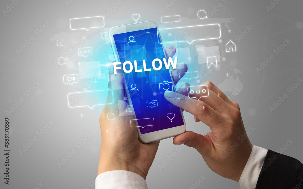 Female hand typing on smartphone with FOLLOW inscription, social media concept Female hand typing on smartphone with FOLLOW inscription, social media concept