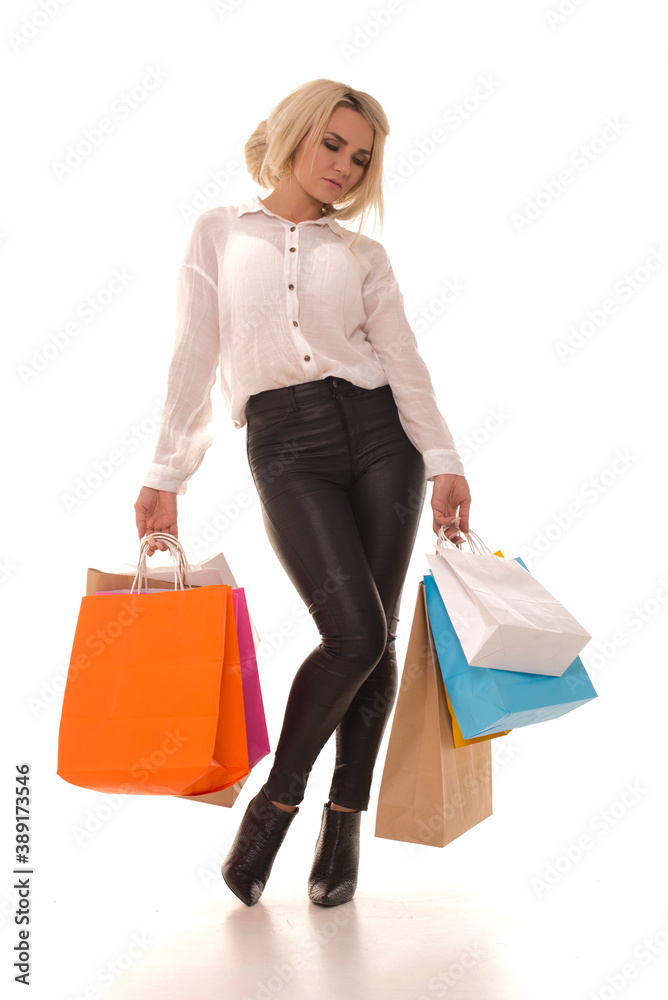 Tired girl after shopping stands on a white background.Tired woman walking after a big sale with purchases in her hands. Tired girl after shopping stands on a white background.Tired woman walking after a big sale with purchases in her hands.