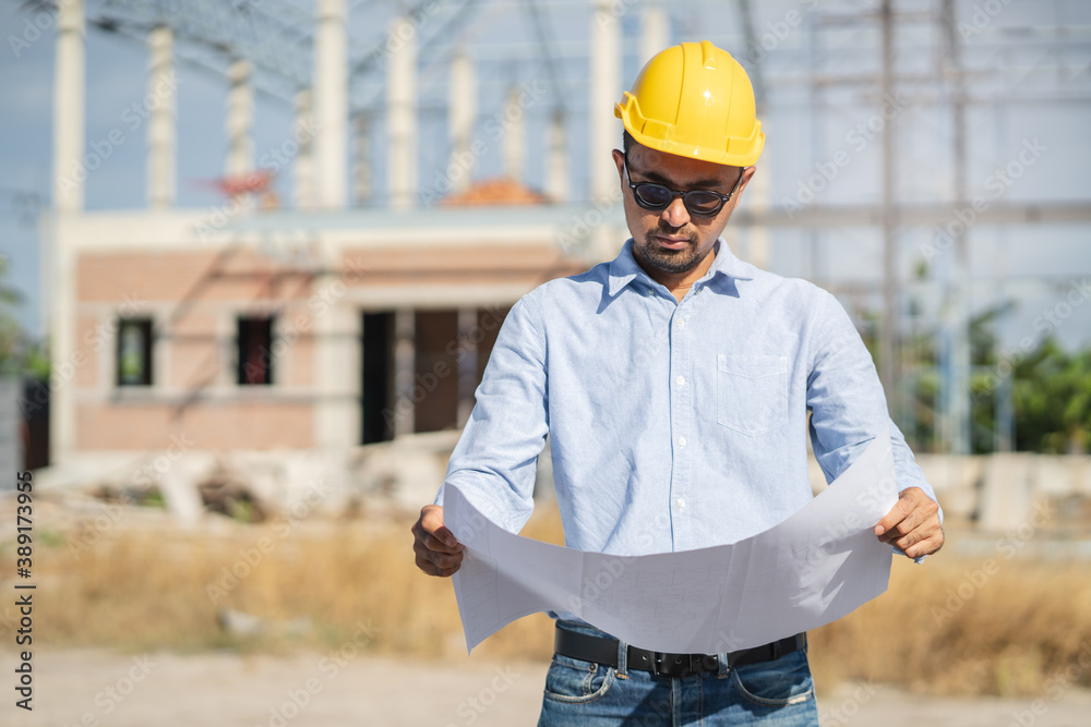 Engineer checking blueprint for property construction. Engineer checking blueprint for property construction.