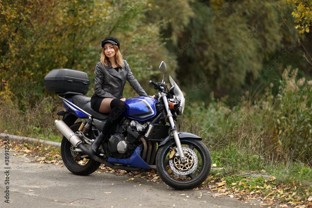 Beautiful slim woman sitting on the motorcycle