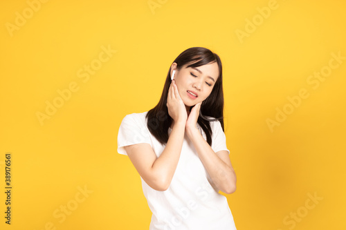 Happy smiling asian young girl with earphones listening music