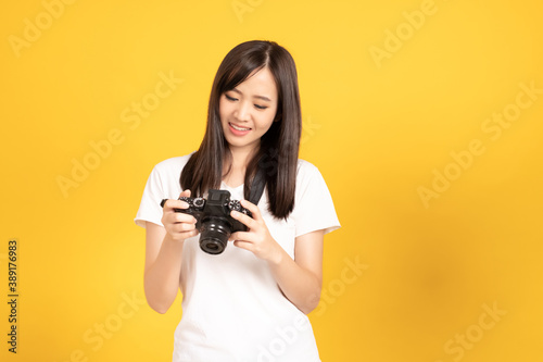 Happy smiling asian young girl photographer and looking viewfinder