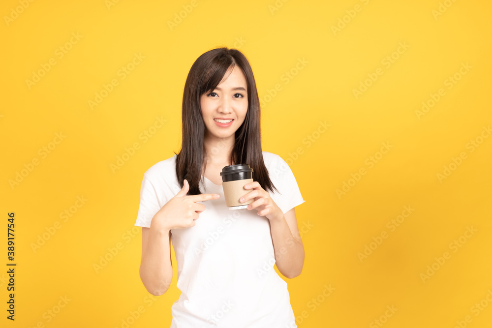Happy asian young woman wearing white t-shirt standing and holding a coffee Happy asian young woman wearing white t-shirt standing and holding a coffee