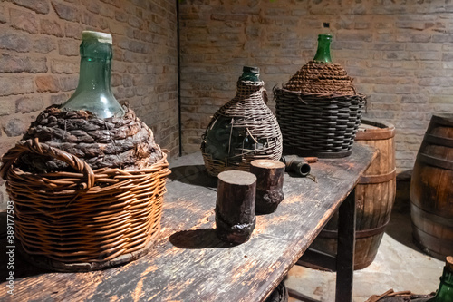Canvastavla Ancient wine barrels and demijohns in a cellar.