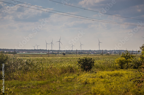 Windwheels and a field in rural Ukraine. Wind farm near the village photo