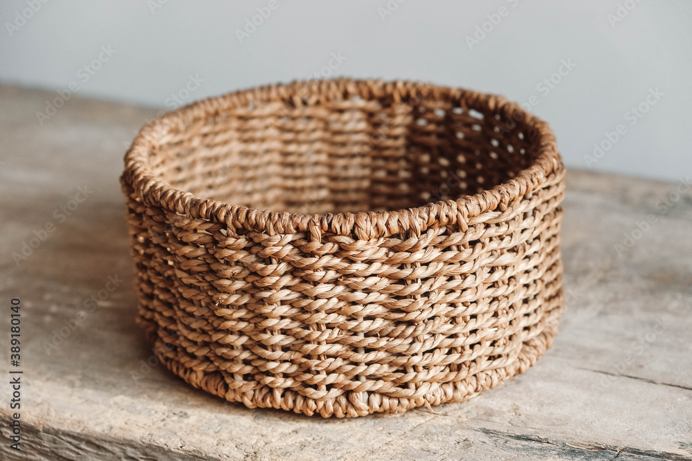 Empty round wicker basket on a old wooden table. Copy, empty space for text Empty round wicker basket on a old wooden table. Copy, empty space for text