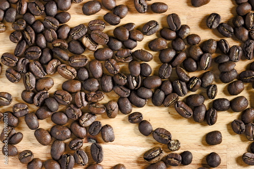 Top down view of spread coffee beans on wooden table. Concept of coffee culture.