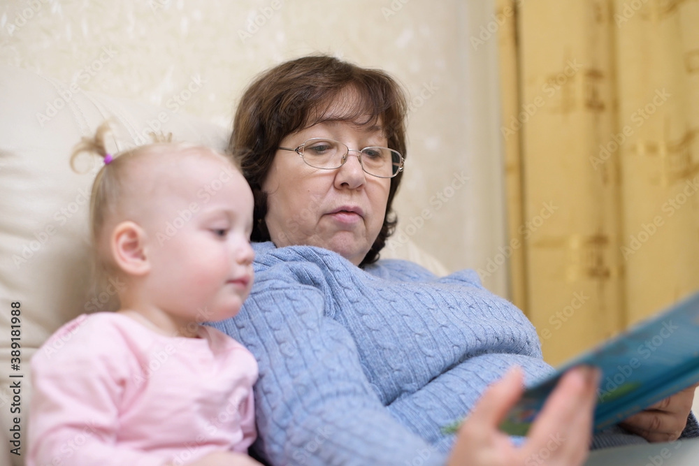 grandmother shows granddaughter a children's book, selective focus on woman grandmother shows granddaughter a children's book, selective focus on woman