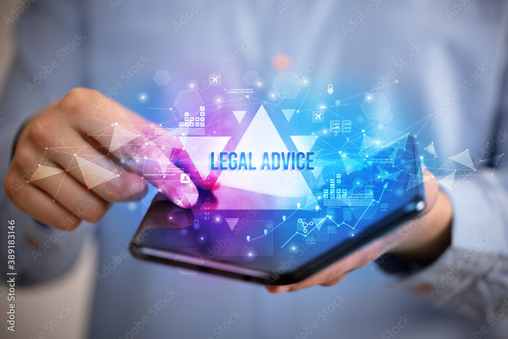 Businessman holding a foldable smartphone with LEGAL ADVICE inscription, business concept Businessman holding a foldable smartphone with LEGAL ADVICE inscription, business concept