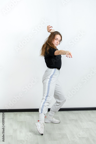 Fototapeta Naklejka Na Ścianę i Meble -  Young beautiful athletic girl dancing hip-hop in the studio