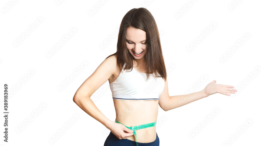 pretty caucasian girl.Weight loss, slim body, diet, sport, fitness and health concept. young woman measures her ideal figure, waist with a centimeter tape on a white background. isolated. copy space pretty caucasian girl.Weight loss, slim body, diet, sport, fitness and health concept. young woman measures her ideal figure, waist with a centimeter tape on a white background. isolated. copy space