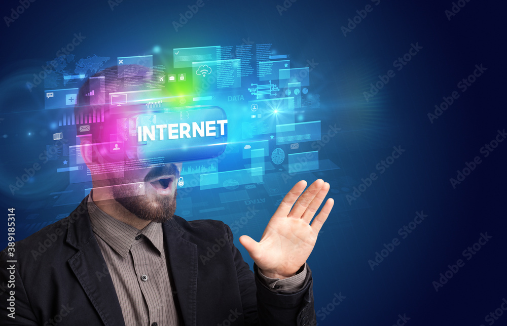 Businessman looking through Virtual Reality glasses with INTERNET inscription, innovative security concept Businessman looking through Virtual Reality glasses with INTERNET inscription, innovative security concept