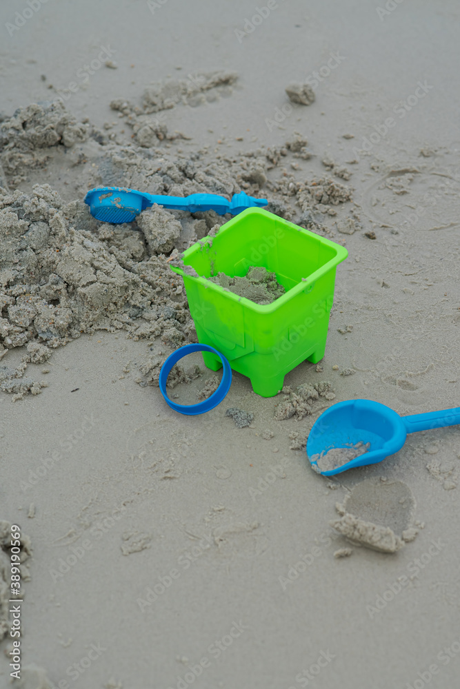 Bright bucket with sand lying by the beach. Bright bucket with sand lying by the beach.