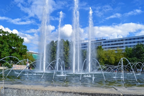 Fountain and blue sky during sunny day. A working fountain near the red tower in the city center of the Chemnitz, East Germany.