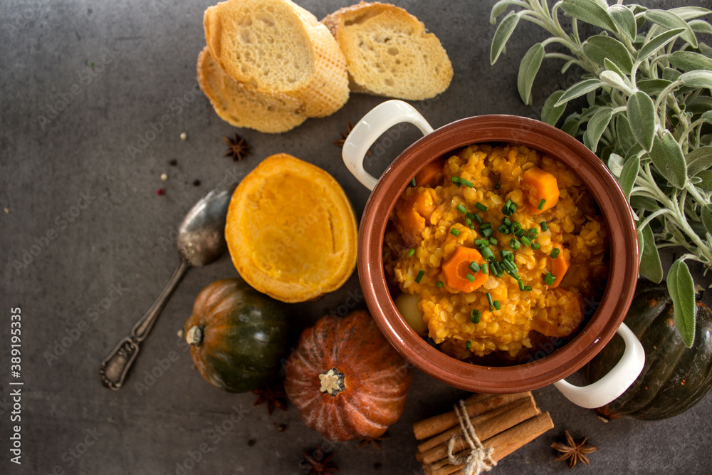 Pumpkin stew with lentils and chickpeas. Balanced vegetarian meal top view photo. Autumn receipts. Dark grey background with copy space.
