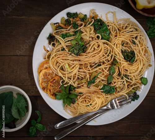 Vegan lemon and basil infused spaghetti dish on wooden table