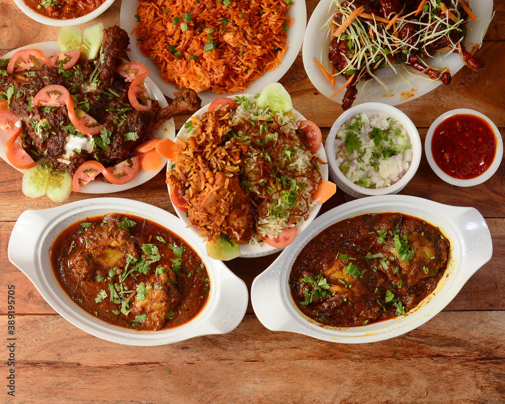 Assorted indian foods chicken biryani,chicken masala,chicken korma and chicken lollipop on wooden background. Dishes and appetizers of indian cuisine Assorted indian foods chicken biryani,chicken masala,chicken korma and chicken lollipop on wooden background. Dishes and appetizers of indian cuisine