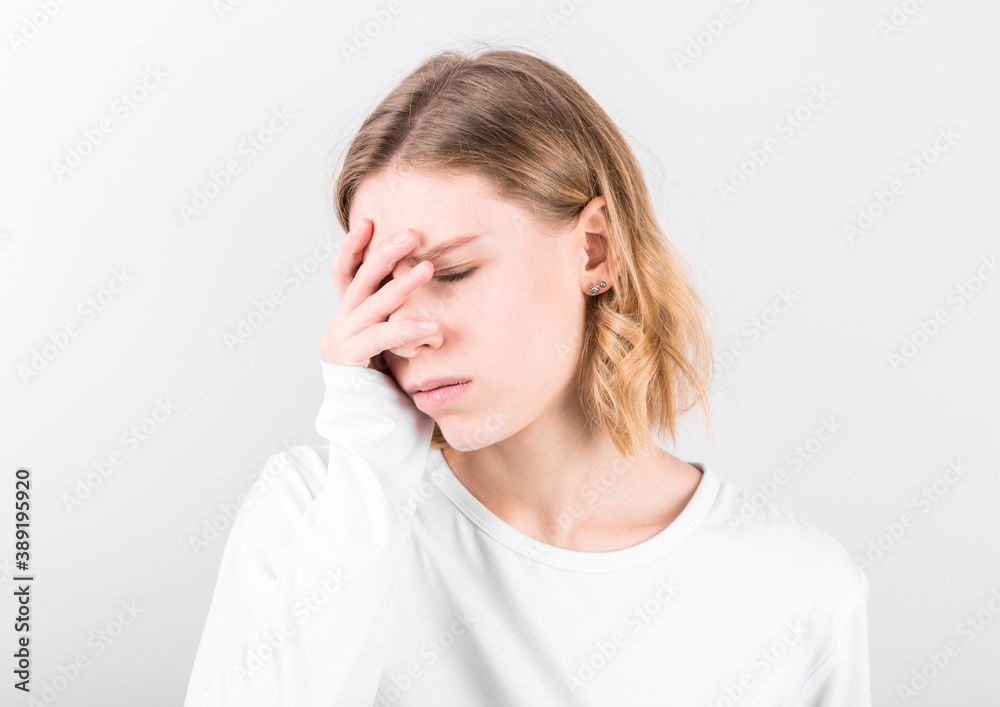 Portrait of beautiful young woman touching her temples feeling stress, on gray background Portrait of beautiful young woman touching her temples feeling stress, on gray background