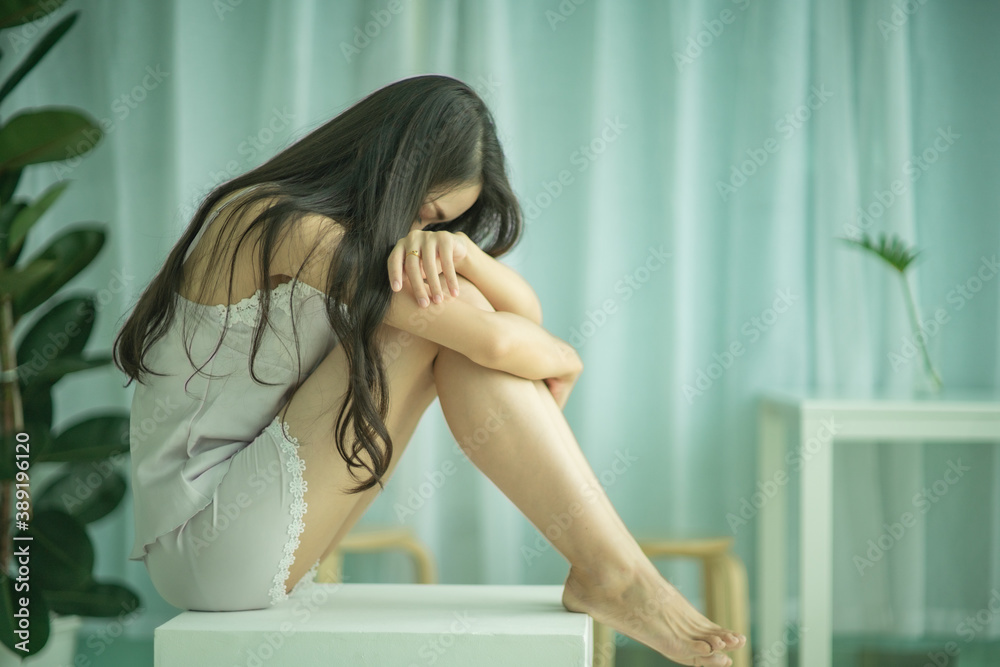 Lonely sad young girl is sitiing and holding her knees. Concept of domestic violence, abuse and harassment. Lonely sad young girl is sitiing and holding her knees. Concept of domestic violence, abuse and harassment.