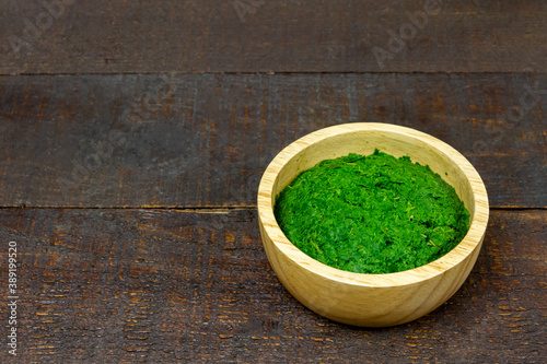 Neem leaf used as ayurvedic medicine on wooden bowl and wooden background. Neem leaf is an excellent moisturizing and contains various compounds that have insecticidal and medicinal properties.
