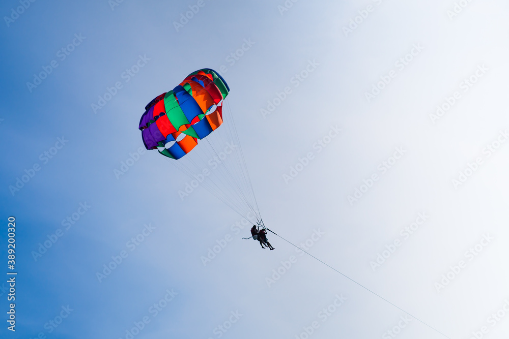 Parasailing in blue sky. Sports, active leisure, travel, vacation concept Parasailing in blue sky. Sports, active leisure, travel, vacation concept