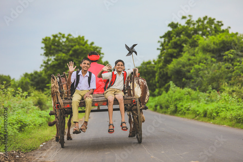 Indian farmer and his child on bullock cart
