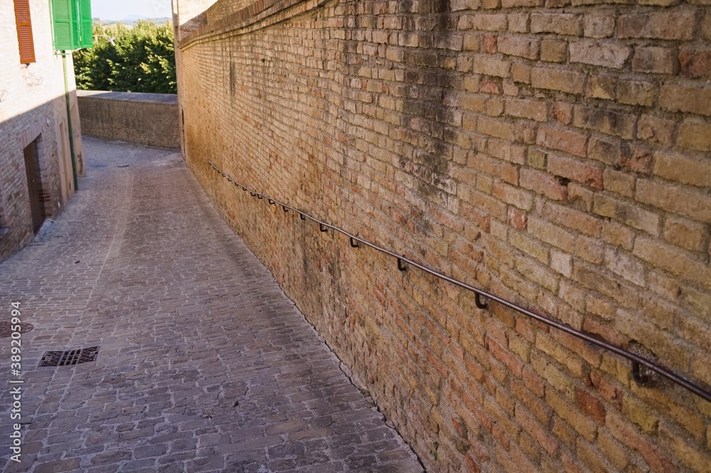 A brick wall in a medieval village with an iron railing (Corinaldo, Marche, Italy)