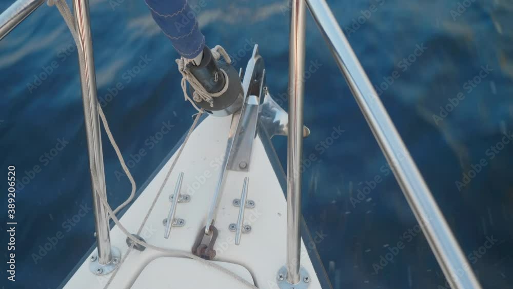 Up view of curtailed sail and jib furler on yacht sailing on river