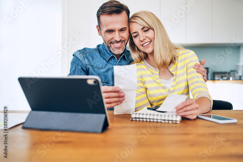 Happy couple planning home budget sitting together