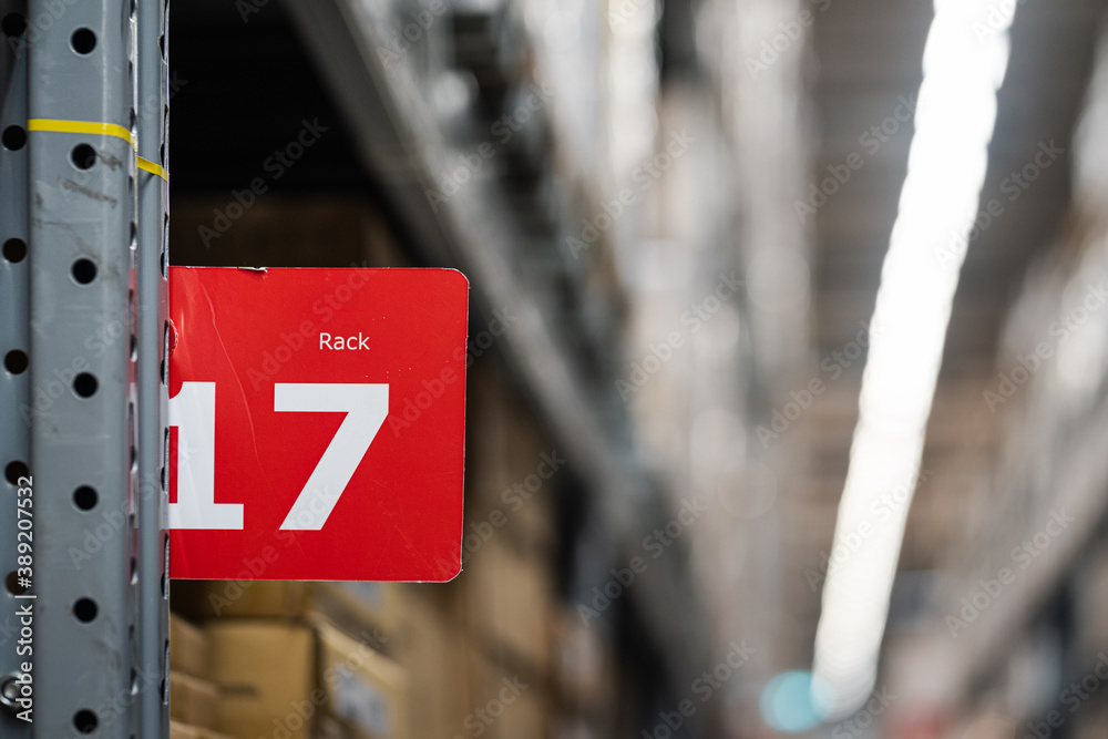 A rack's number sign with blurred background of products shelves in very huge warehouse storage.