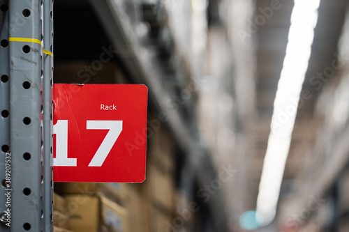 A rack's number sign with blurred background of products shelves in very huge warehouse storage.