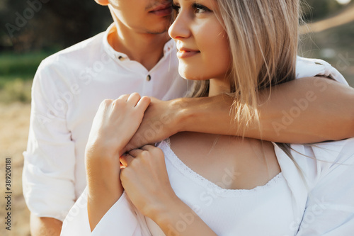 Obraz na płótnie Close up cropped photo of happy blonde girl and passionate man. He hugs her from the back. w salonie