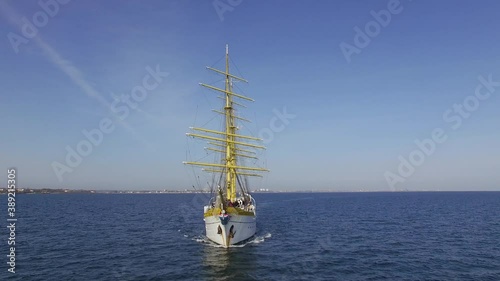 Aerial front view of a navy training ship near the coastline on a sunny day in the Black Sea. Three-masted bark/barque type with square rigging. Romanian flag photo