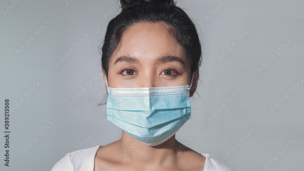 Woman wear medical mask protecting from coronavirus pandemic. close up of asian woman wear surgical medical mask.