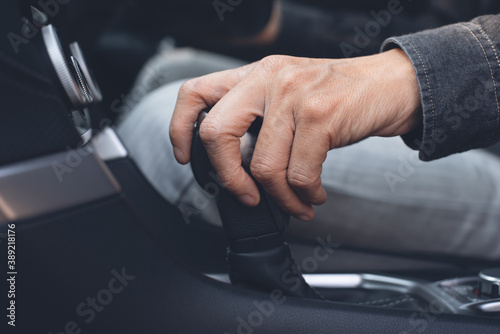 Close up of man driving a car and gear automatic transmission