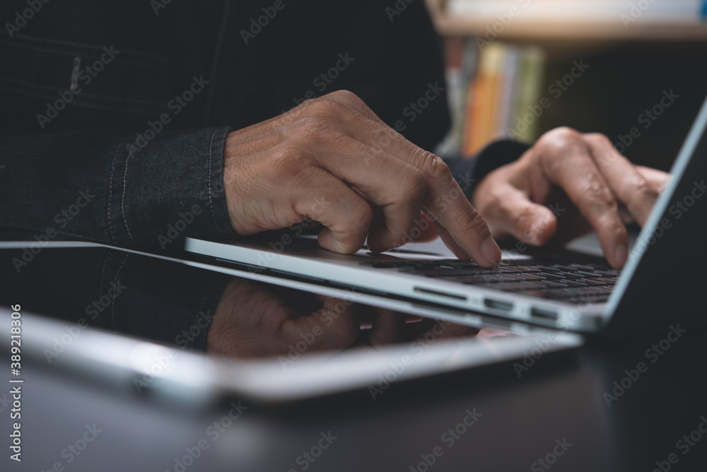 Man hand typing on laptop computer keyboard surfing the internet on table in office Man hand typing on laptop computer keyboard surfing the internet on table in office