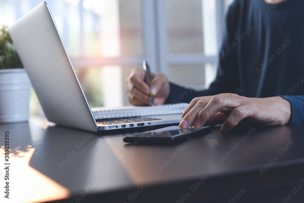 Student searching internet while online studying on laptop computer and mobile smartphone on table Student searching internet while online studying on laptop computer and mobile smartphone on table