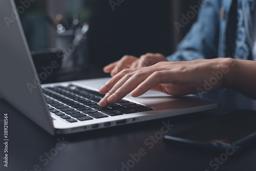 Close up of woman hand typing on laptop computer and surfing the internet