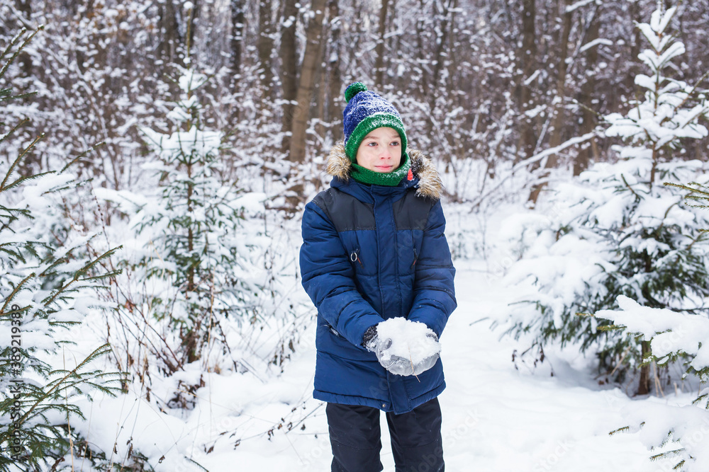 Happy boy throwing snow. Child, season and winter concept.