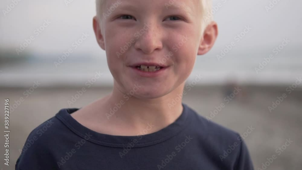 Close-up of the face of a beautiful blonde boy against the sea. Close-up of the face of a beautiful blonde boy against the sea.