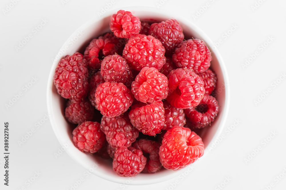 Fresh raspberries in a bowl isolated on white background, top view Fresh raspberries in a bowl isolated on white background, top view