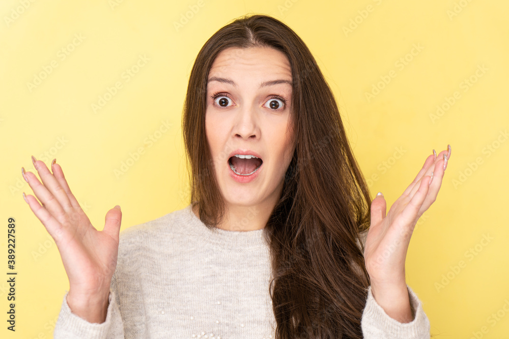 Joyfully shocked Tatar brunette girl splashes her hands with open mouth and surprised face isolated in yellow studio. Good news, sale concept Joyfully shocked Tatar brunette girl splashes her hands with open mouth and surprised face isolated in yellow studio. Good news, sale concept