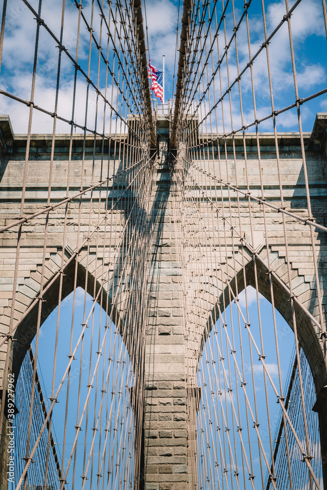 Fototapeta premium American flag flying over the Brooklyn Bridge