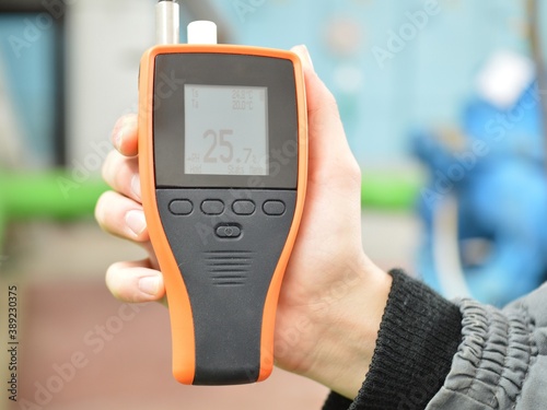 Checking the air condition with the device. Measurement of air temperature and humidity. Part of the image is blurred. photo