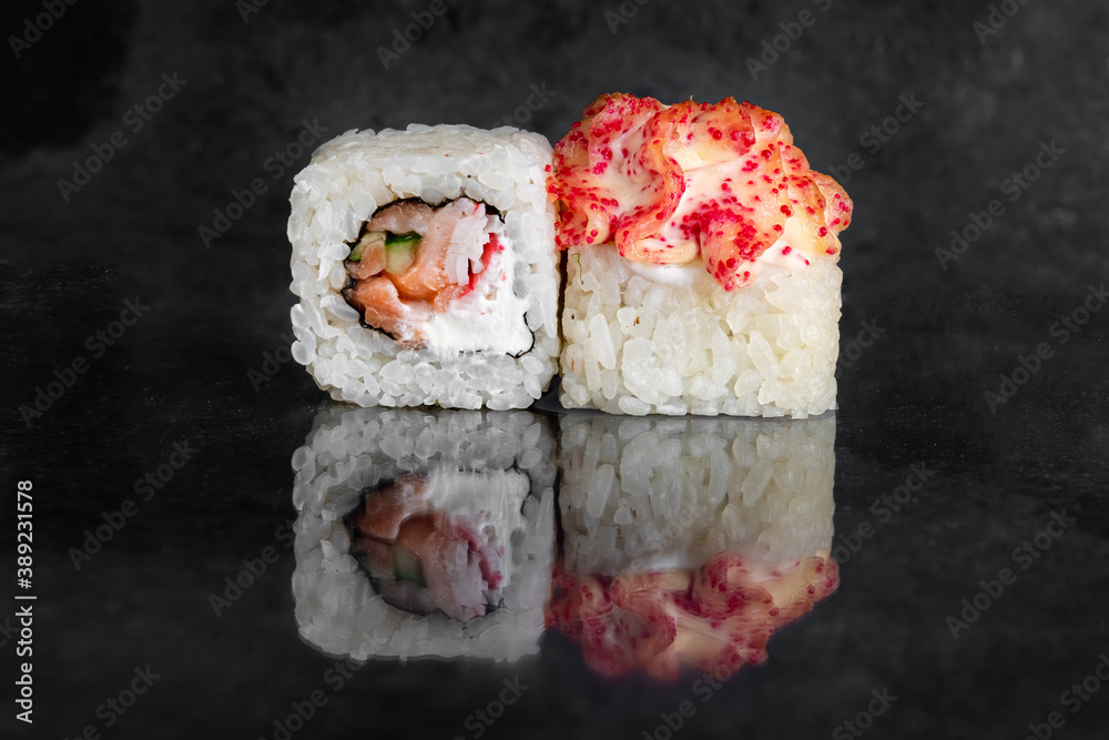 Rolls with crab, salmon, cucumber and cream cheese on a dark background with reflection Rolls with crab, salmon, cucumber and cream cheese on a dark background with reflection